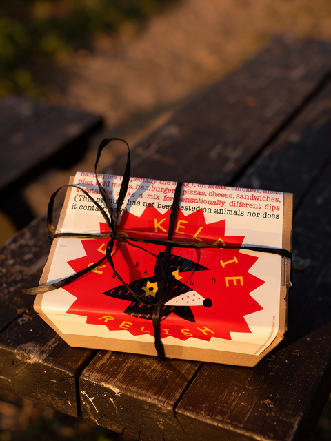 A Red Kelpie Relish gift-wrapped package tied with twine on a wooden bench.